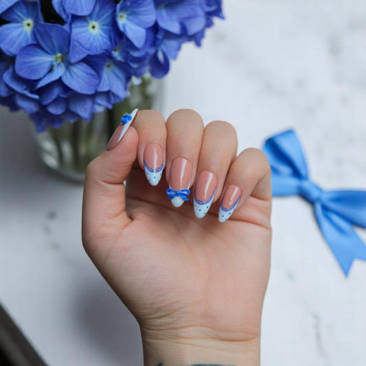 Elegant 3D blue bow press-on nails with white French tips, blue lace and dots, medium almond shape — handmade for weddings and birthdays.
